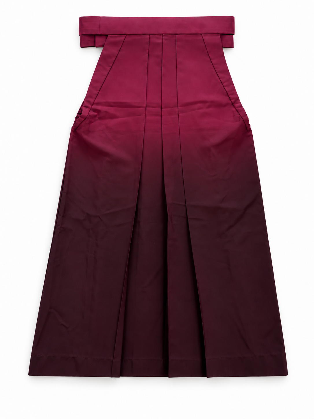 The back side of a pleated traditional Japanese hakama skirt with a wide waistband and bow detail, shown flat against a plain white background. The hakama features a deep wine red to dark burgundy ombré color gradient.