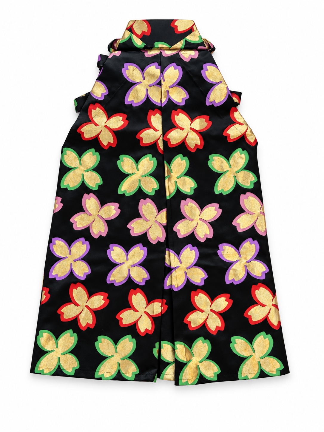 The back side of a  black pleated traditional Japanese hakama pants with  vibrant, repeating floral pattern of gold, green, red, pink and purple flowers, shown against a plain white background.