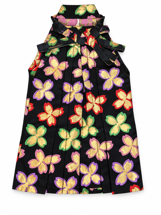 A  black pleated traditional Japanese hakama pants with and bow details, covered in a colorful gold metallic cherry blossom in purple, pink, red and green on a white background.