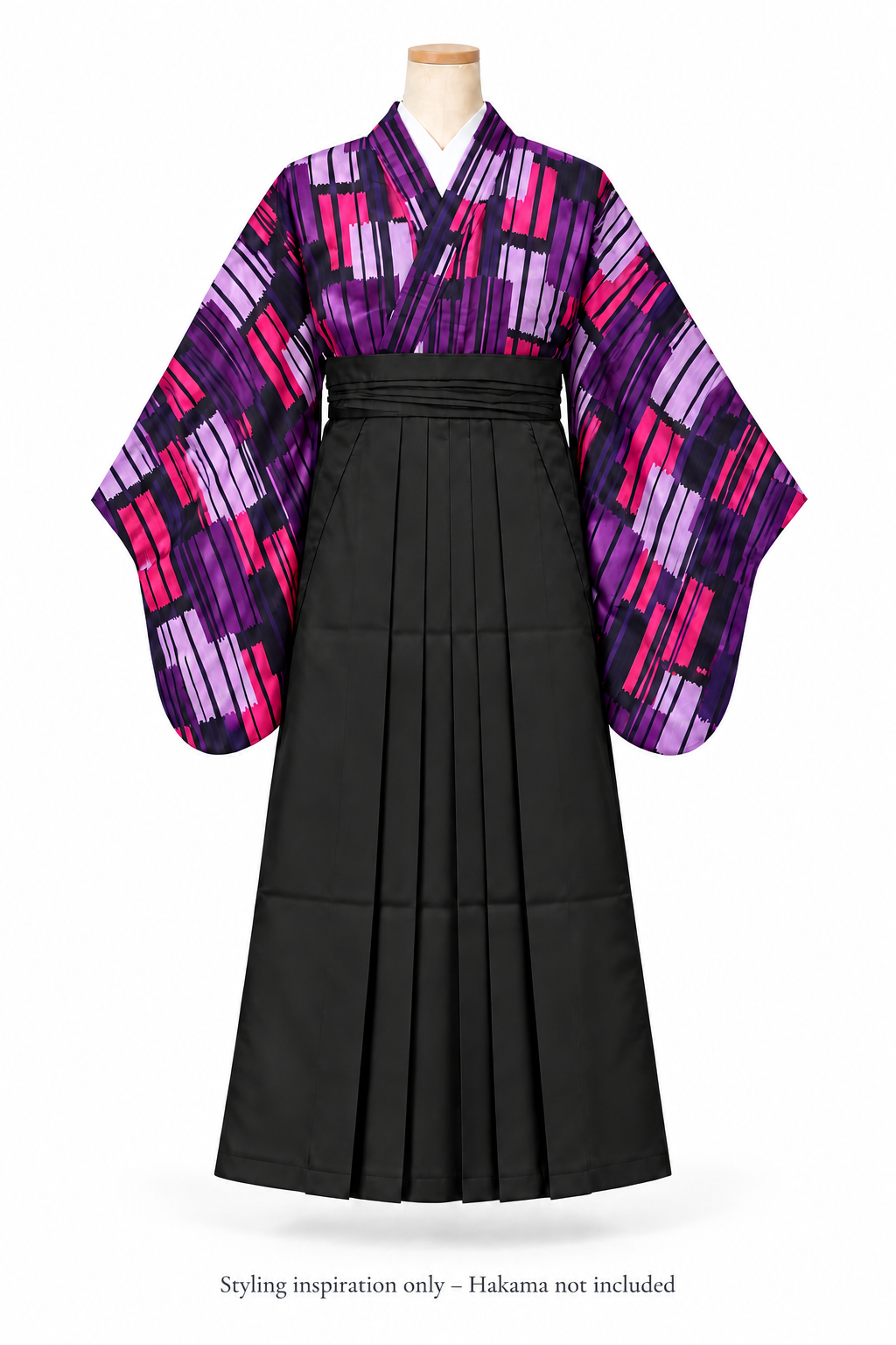 A traditional Japanese furisode kimono with hakama displayed on a mannequin against a white background. The garment features a black pleated hakama-style skirt and wide sleeves with a bold purple, pink, and black geometric pattern. With a message at the botton "Styling inspiration only - hakama not included"